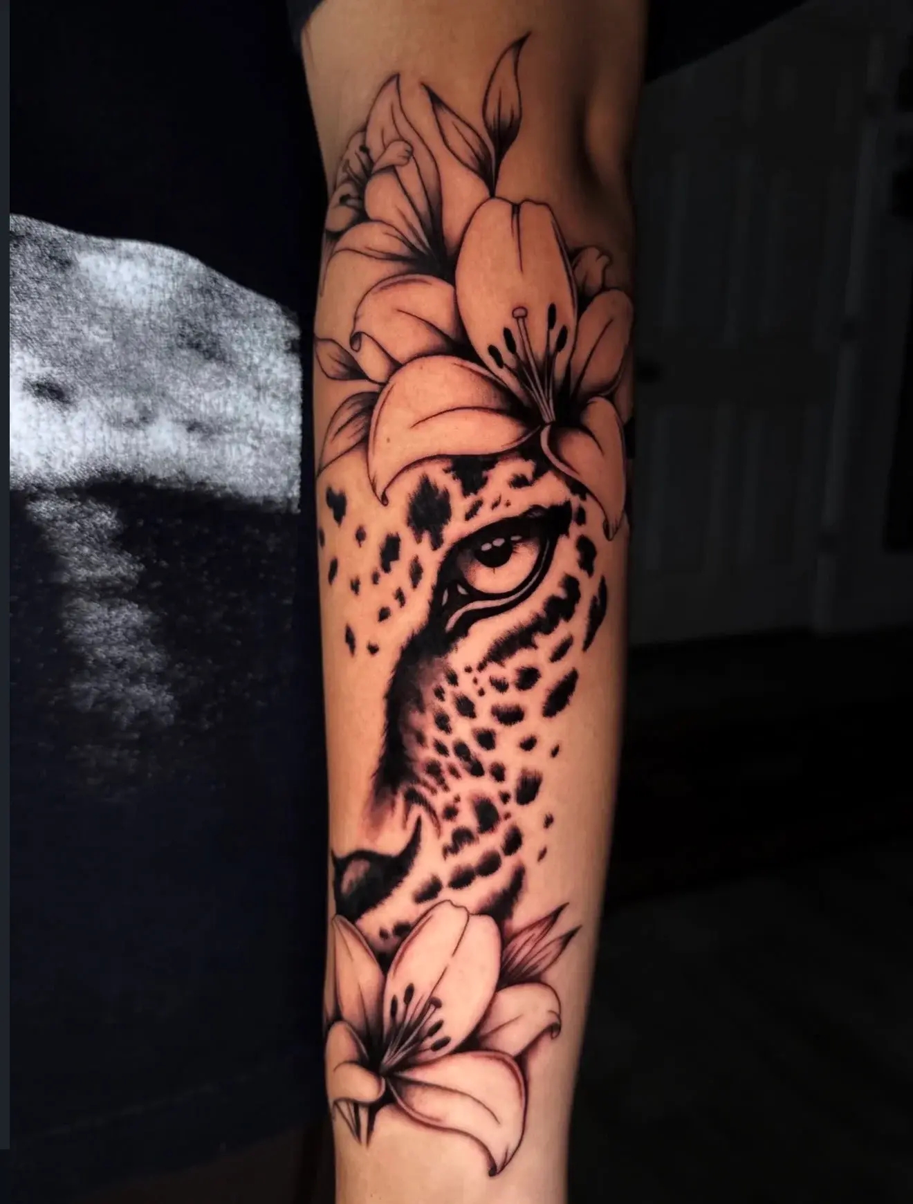 Leopard face with lilies tattoo by Lucia