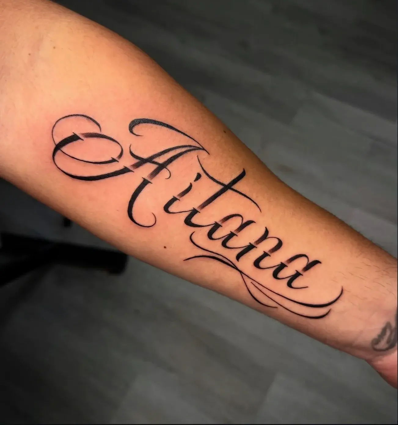 Aitana script lettering tattoo by Lucia
